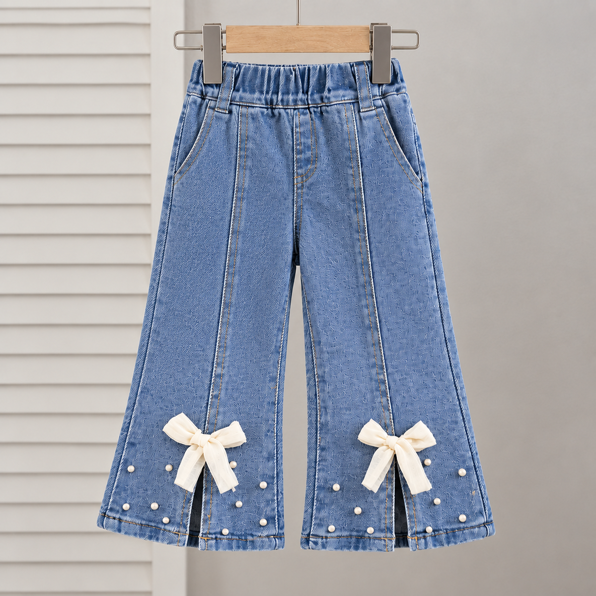 Stylish girls outfit with a modern touch - black top with stylish bowknot and attractive pleated jeans