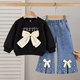 Stylish girls outfit with a modern touch - black top with stylish bowknot and attractive pleated jeans