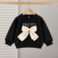 Stylish girls outfit with a modern touch - black top with stylish bowknot and attractive pleated jeans