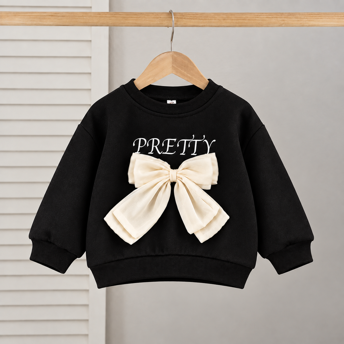 Stylish girls outfit with a modern touch - black top with stylish bowknot and attractive pleated jeans