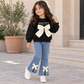 Stylish girls outfit with a modern touch - black top with stylish bowknot and attractive pleated jeans