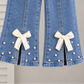 Stylish girls outfit with a modern touch - black top with stylish bowknot and attractive pleated jeans